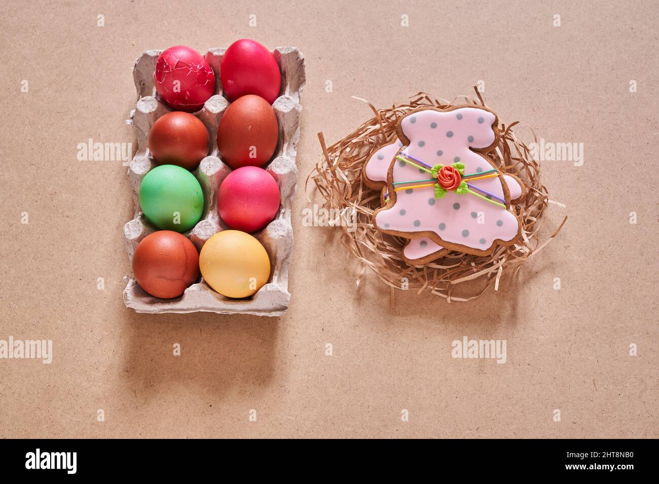 Draufsicht auf Ostereier und Lebkuchen in Form eines Hasen auf sandigen Hintergrund. Minimales Konzept.mit Platz zum Kopieren. Hochwertige Fotos Stockfoto