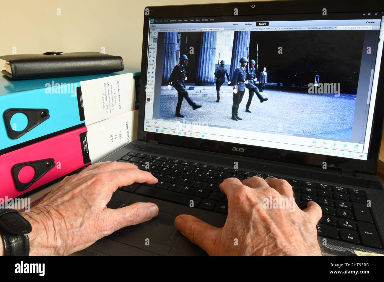 Alte Hände an einer Computertastatur, die Bilder finden, um angenehme Erinnerungen auszulösen, wenn man älter wird. Ostberlin war interessant und zum Nachdenken anregend Stockfoto