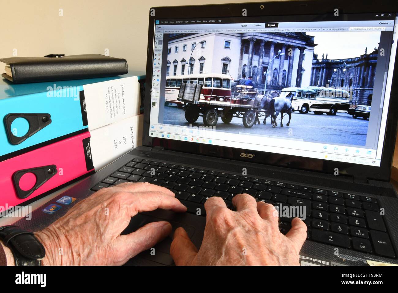 Alte Hände an einer Computertastatur, die Bilder finden, um angenehme Erinnerungen auszulösen, wenn man älter wird. Der Transport in Ost-Berlin war interessant und alt Stockfoto