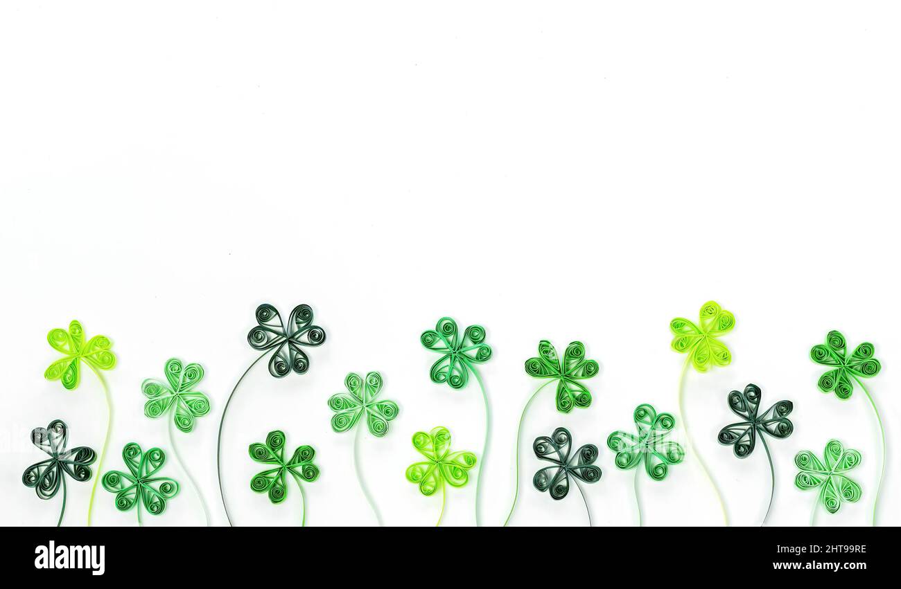 Quilling Kleeblatt geht zum St. Patrick's Day Banner. Grüne Kleeblätter aus gerolltem Papier isoliert auf weißem Hintergrund. Hintergrund für St. Pat Stockfoto