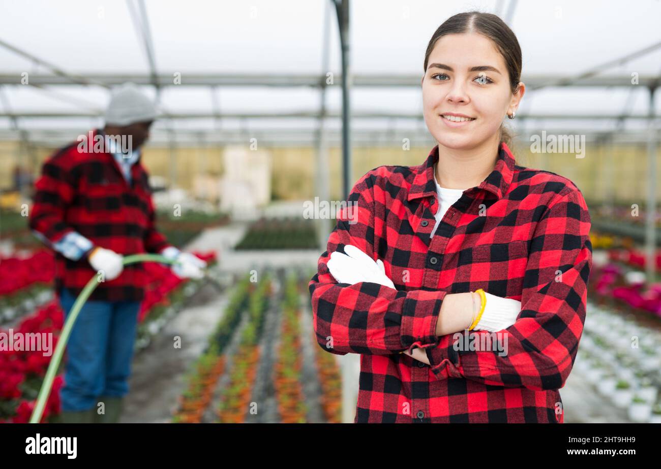 Porträt einer jungen Frau im Gewächshaus, wo Blumen angebaut werden Stockfoto