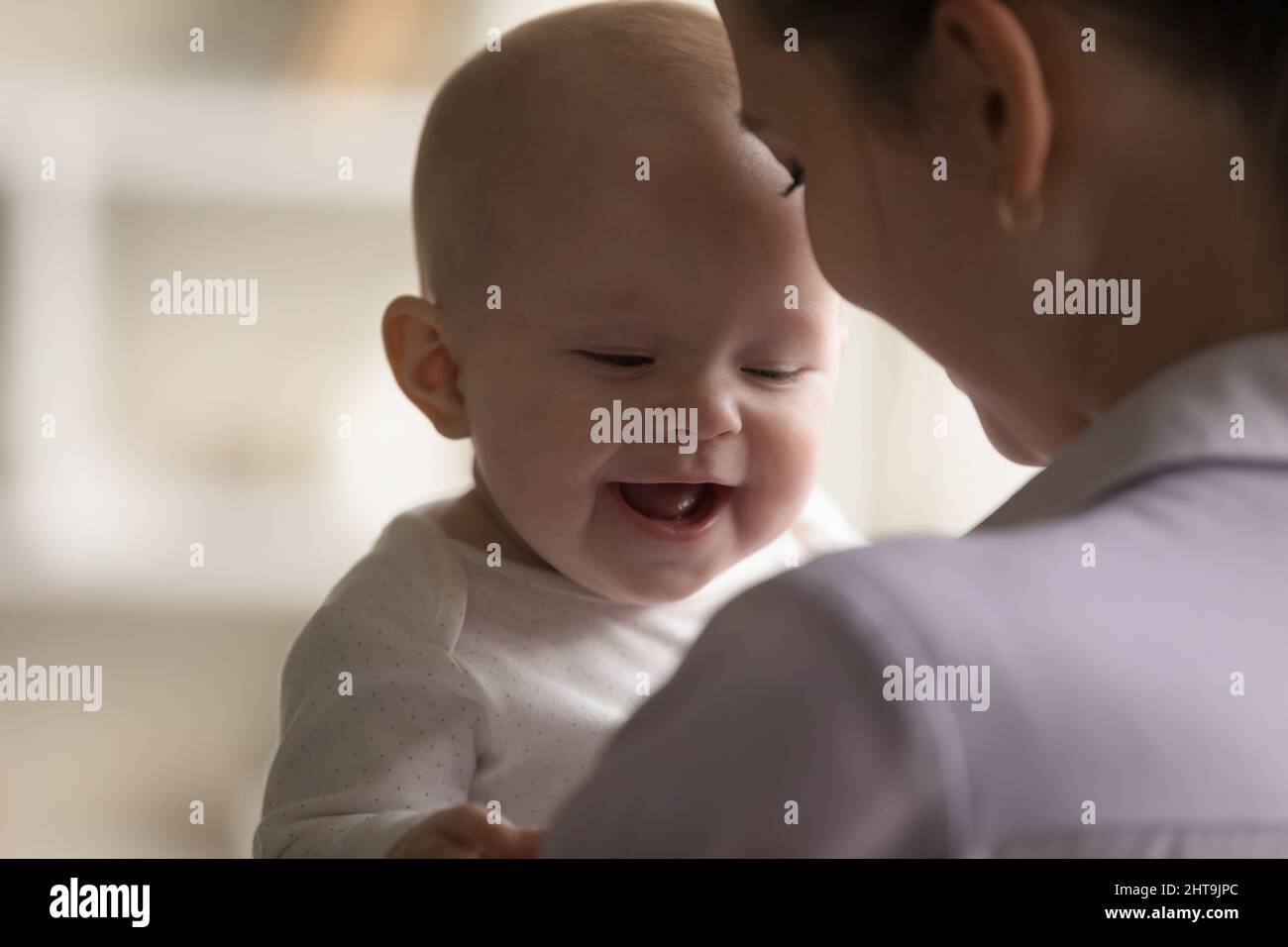 Glücklich fröhlich liebenswert Baby lachend, lächelnd in jungen Müttern Arme Stockfoto