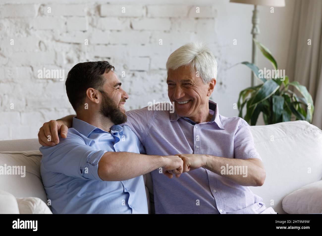 Älterer Vater sein junger erwachsener Sohn ist ein Faustschlag, der Respekt zum Ausdruck bringt Stockfoto