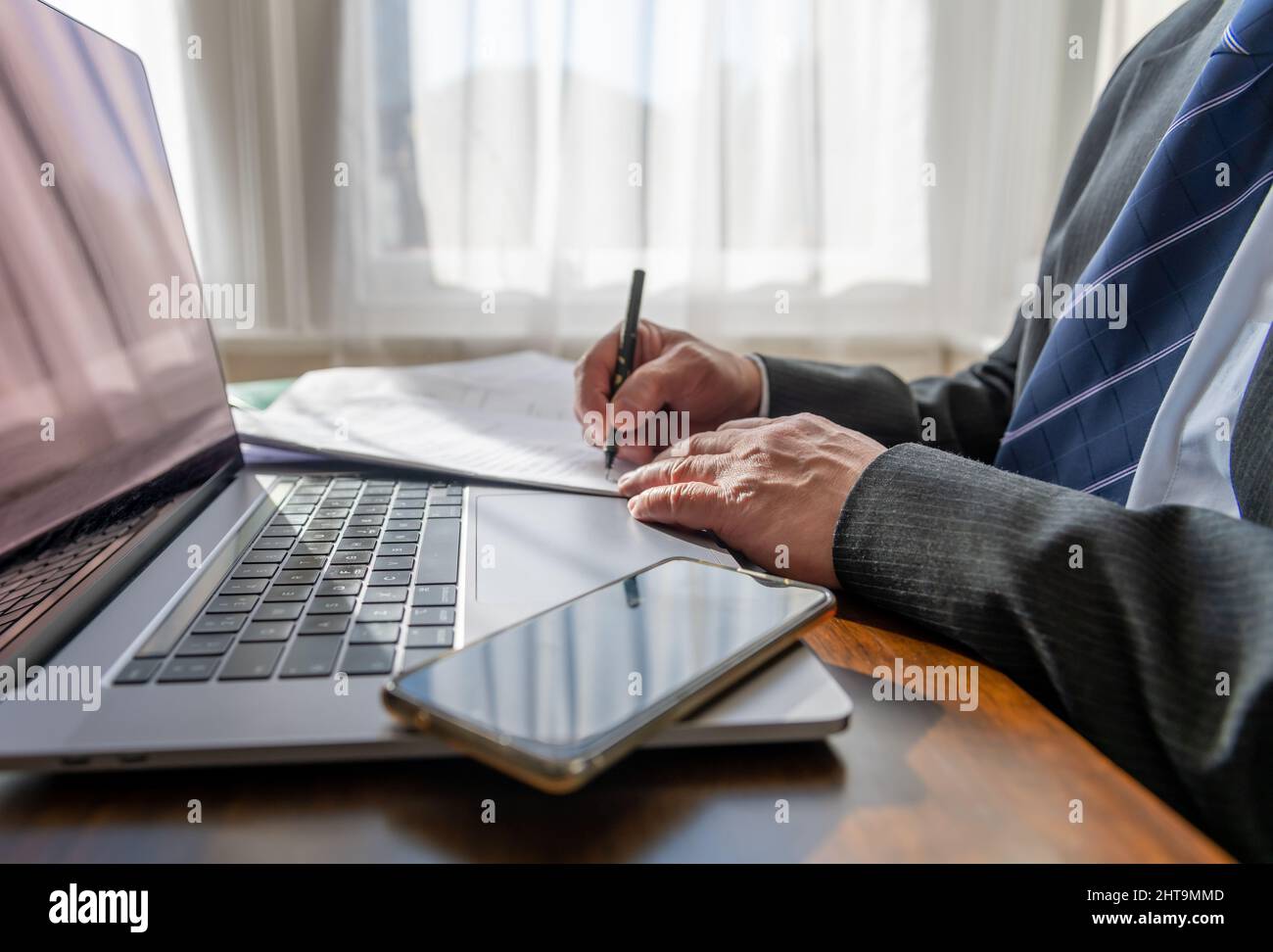 Nahaufnahme eines Geschäftsmanns, der im Büro einen Vertrag unterzeichnet. Stockfoto