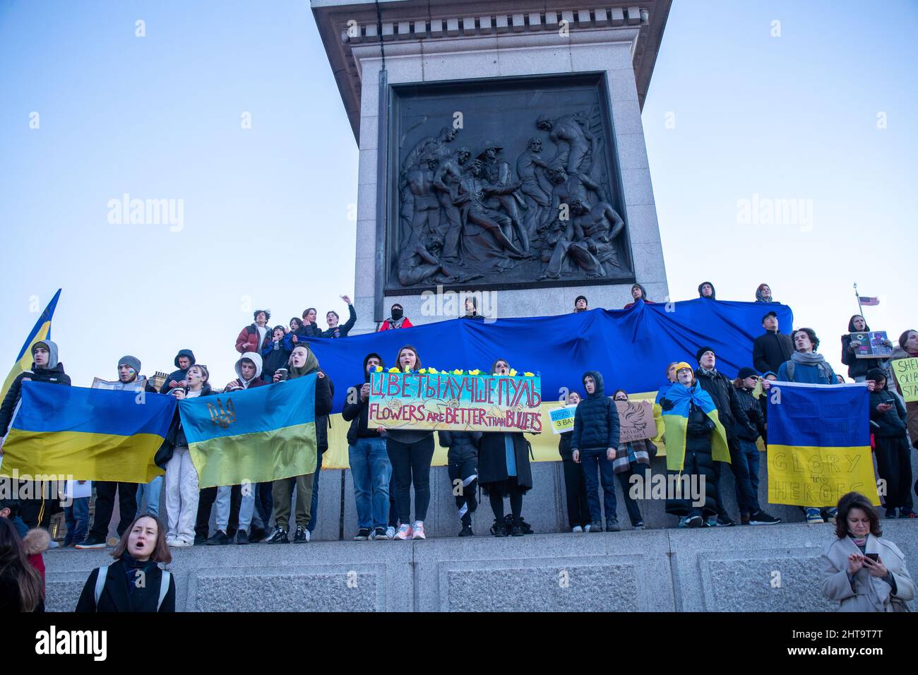 LONDON, FEBRUAR 27 2022 Pro-ukrainische Demonstranten halten die ukrainische Flagge auf der Nelson-Kolonne, während sie auf dem Trafalgar-Platz gegen Russlands Invasion der Ukraine protestieren. Kredit: Lucy North/Alamy Live Nachrichten Stockfoto
