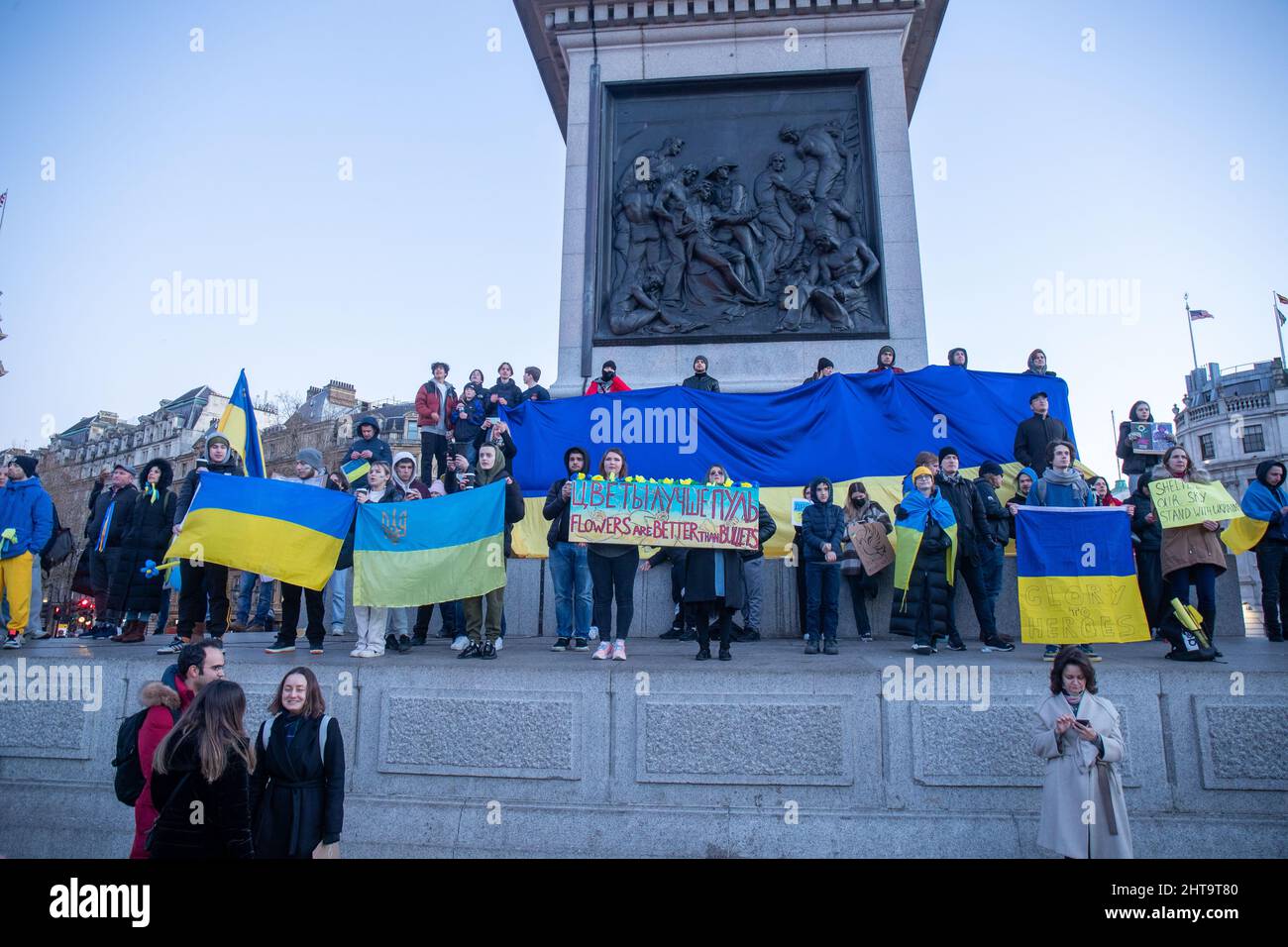 LONDON, FEBRUAR 27 2022 Pro-ukrainische Demonstranten halten die ukrainische Flagge auf der Nelson-Kolonne, während sie auf dem Trafalgar-Platz gegen Russlands Invasion der Ukraine protestieren. Kredit: Lucy North/Alamy Live Nachrichten Stockfoto