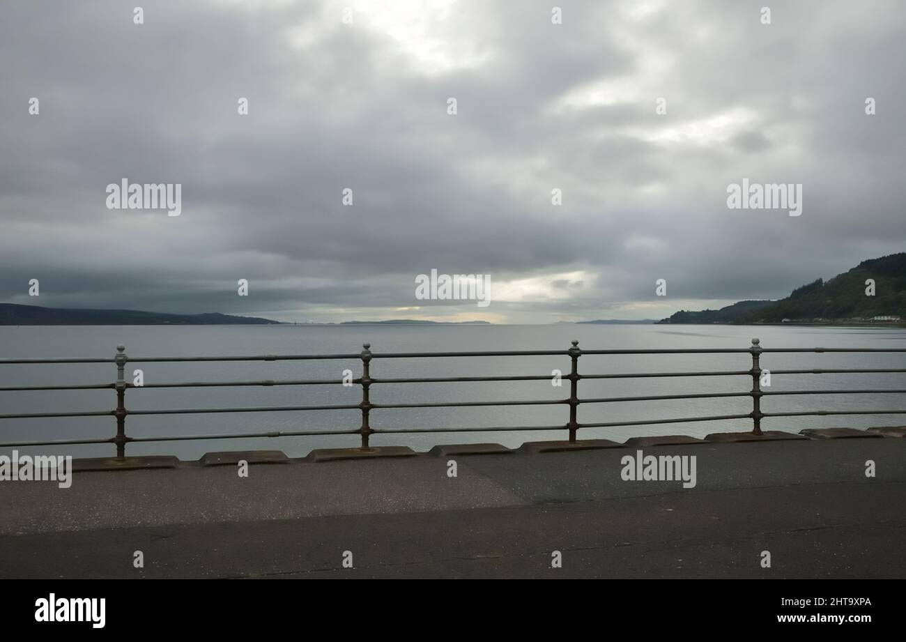 Ein weiter offener Blick von der Stadt Dunoon, mit Blick auf den Firth of Clyde, an einem bewölkten, bewölkten Tag, mit traditionellen Geländern im Vordergrund Stockfoto