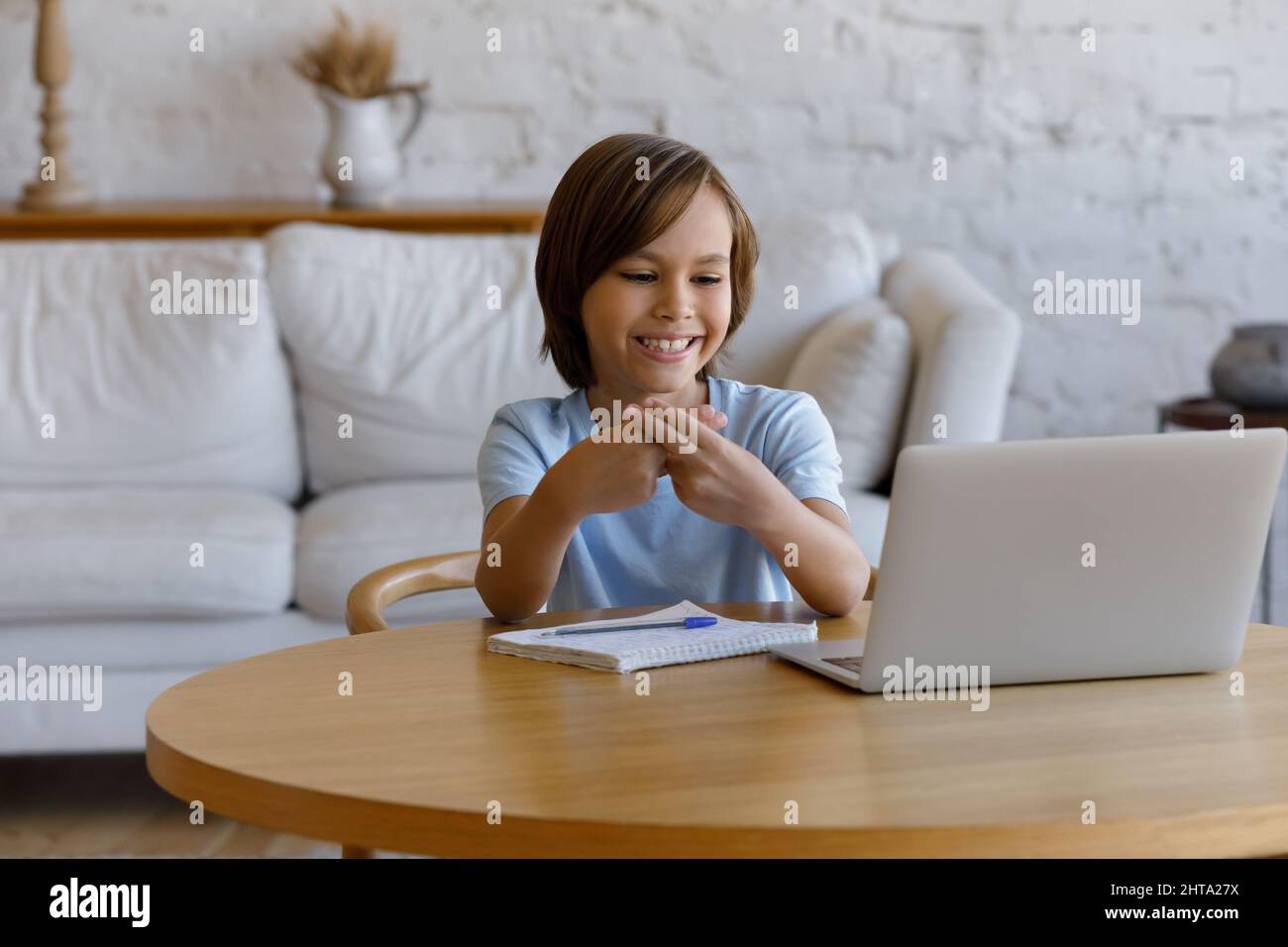 Junge, der auf den Laptop schaut und die Gebärdensprache zeigt, kommuniziert mit dem Tutor Stockfoto