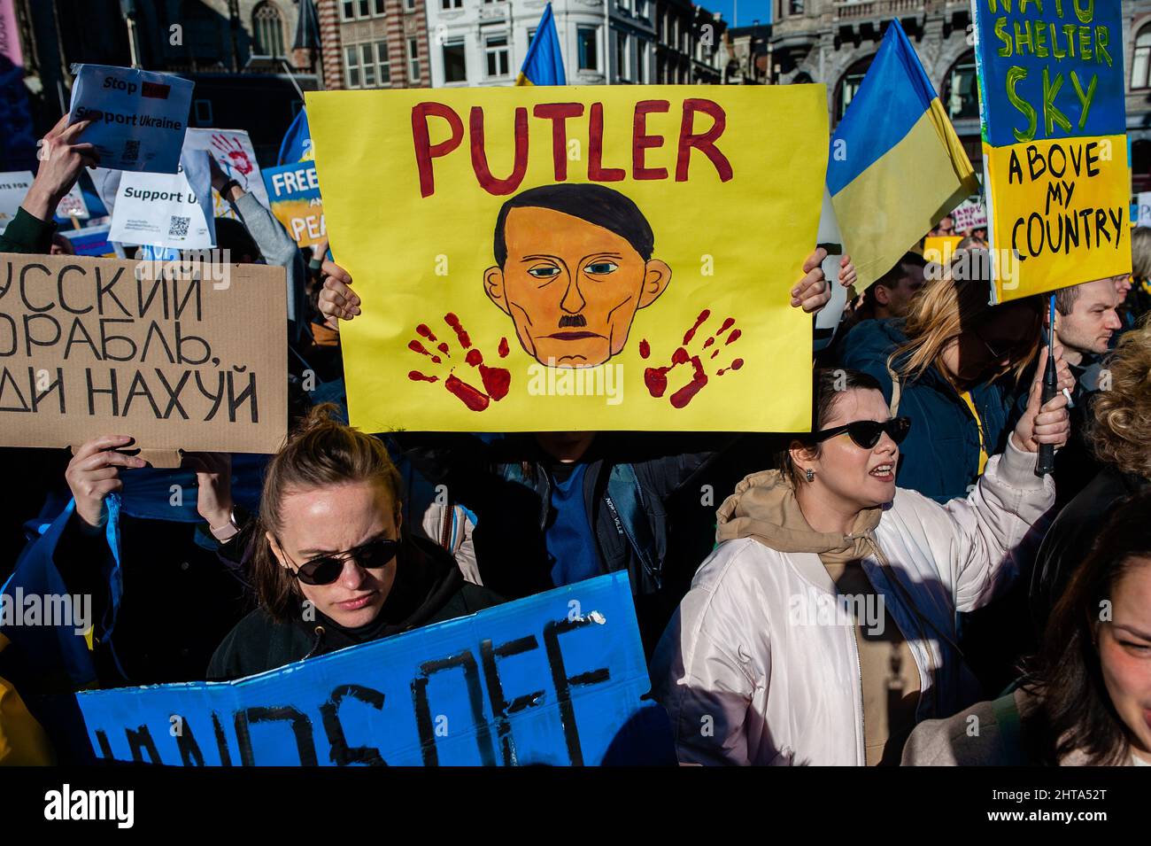 Eine Person hält ein Plakat mit dem Gesicht Putins als Hitler während der massiven Demonstration gegen Putins Invasion der Ukraine, die am 27.. Februar 2022 in Amsterdam organisiert wurde. Nach Putins Entscheidung, die Ukraine anzugreifen, wurden am selben Tag mehrere Proteste im Zentrum der Stadt organisiert, um ihre Unterstützung für das ukrainische Volk zu zeigen. Die ukrainische Gemeinschaft, die russische Gemeinschaft und mehrere Nichtregierungsorganisationen in den Niederlanden, begleitet von Tausenden von Menschen, versammelten sich auf dem Dam-Platz, um gegen Putin und den Krieg in der Ukraine zu protestieren (Foto: Romy Fernandez/Sipa US Stockfoto