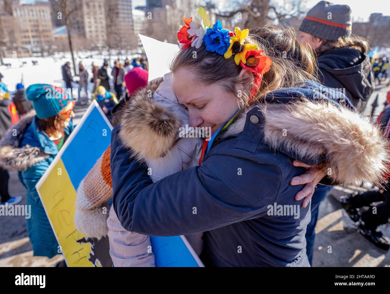 Boston, USA. 27. Februar 2022, Boston, MA USA: Eine ukrainische Frau mit einem traditionellen ukrainischen Blumenkopfteil umarmt ihren alten Nachbarn aus Kiew in Tränen nach dem Friedensmarsch für die Ukraine in Boston. Russland marschierte am 24. Februar 2022 in die Ukraine ein. Quelle: Keiko Hiromi/AFLO/Alamy Live News Stockfoto