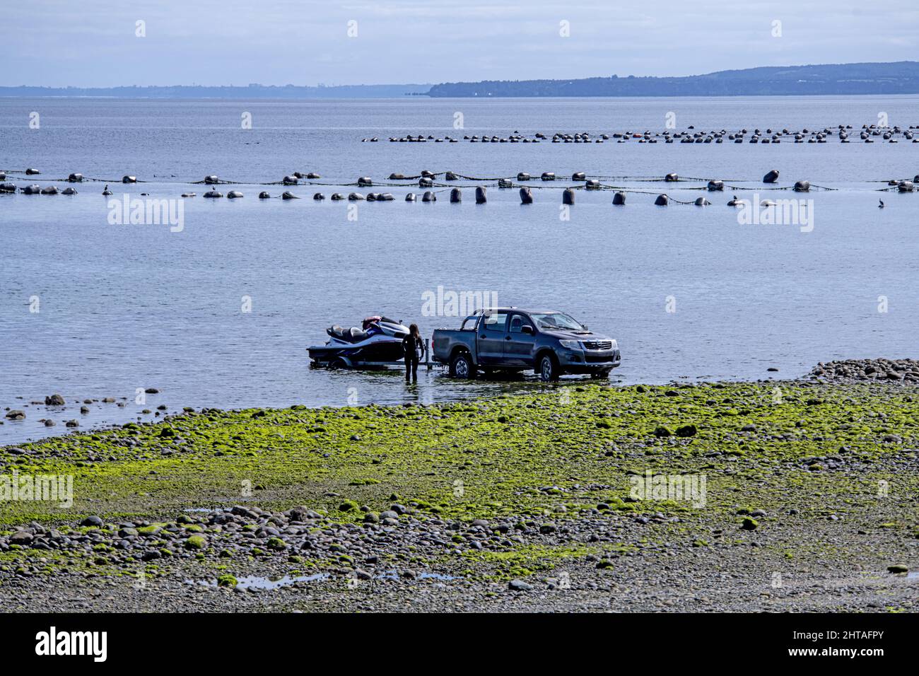 Schöne Aussicht auf ein Auto mit einem Boot im Meer im chilenischen Patagonien Stockfoto