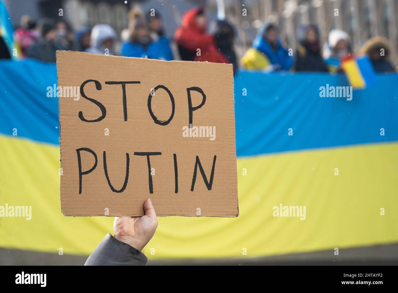 Ein Proteststeller hält ein Schild mit der Aufschrift „Stoppt Putin“ auf einem Stand mit einer Kundgebung der Ukraine zur Solidarität gegen die russische Invasion in Toronto, Ontario, hoch. Stockfoto