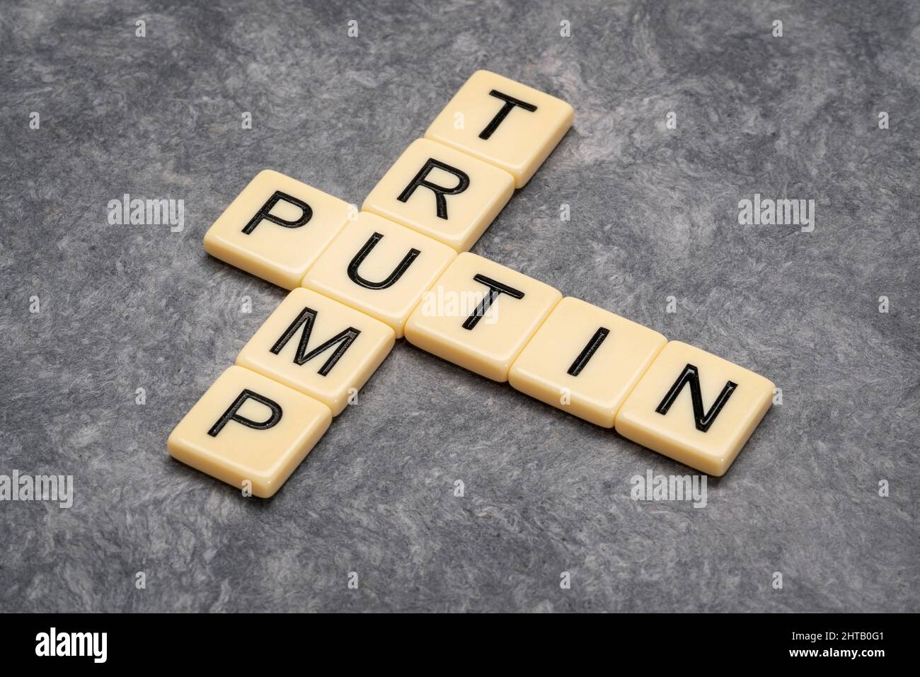 Kreuzworträtsel von Putin und Trump in Elfenbein-Buchstabenkacheln gegen strukturiertes handgefertigtes Papier Stockfoto
