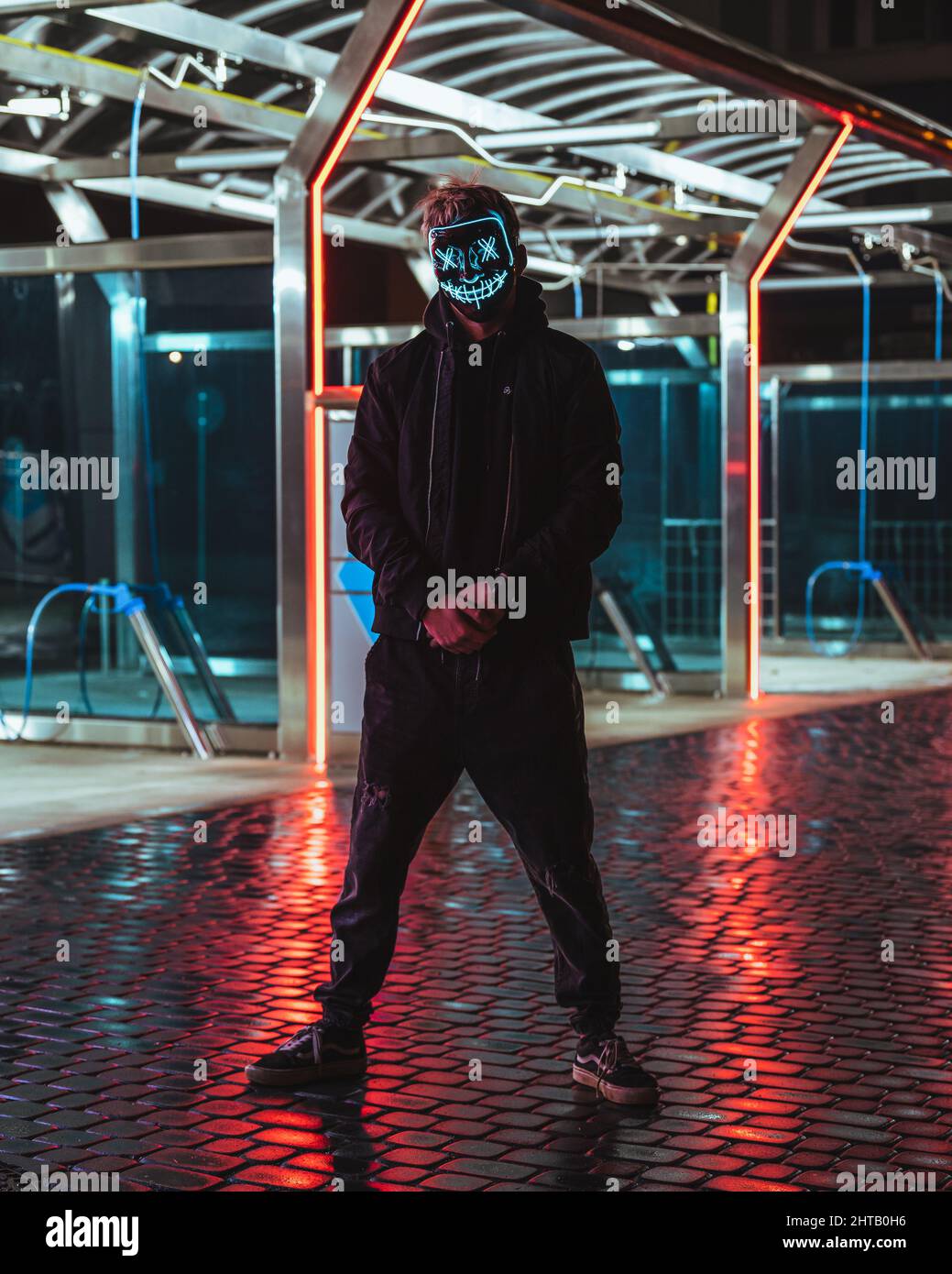 Mann in einer blauen Neonmaske stehend Stockfoto
