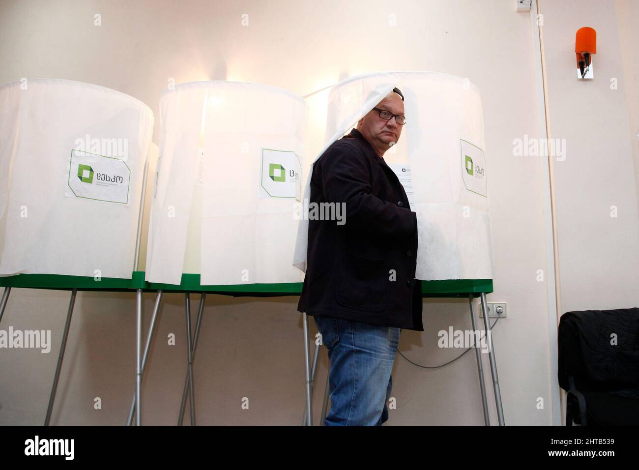 Person gegen die Wahlkästen in Georgien Stockfoto