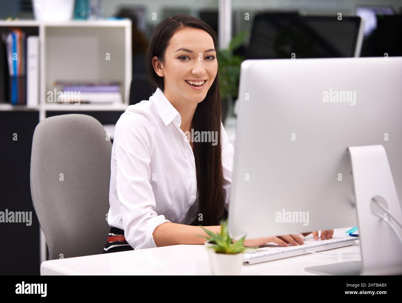 Spaß bei der Arbeit. Porträt einer attraktiven jungen Geschäftsfrau, die an ihrem Schreibtisch arbeitet. Stockfoto