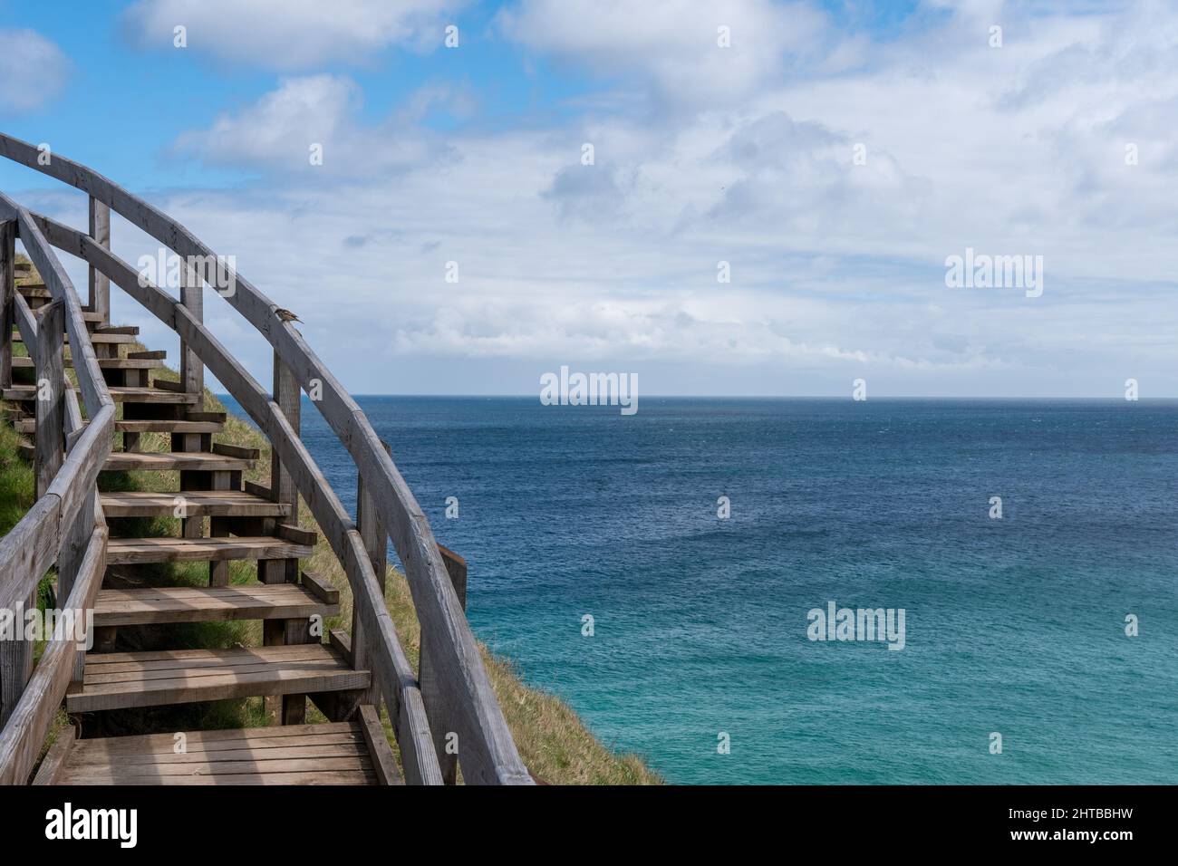 Eine szenische Aufnahme einer gebogenen Holztreppe mit Blick auf das Meer Stockfoto