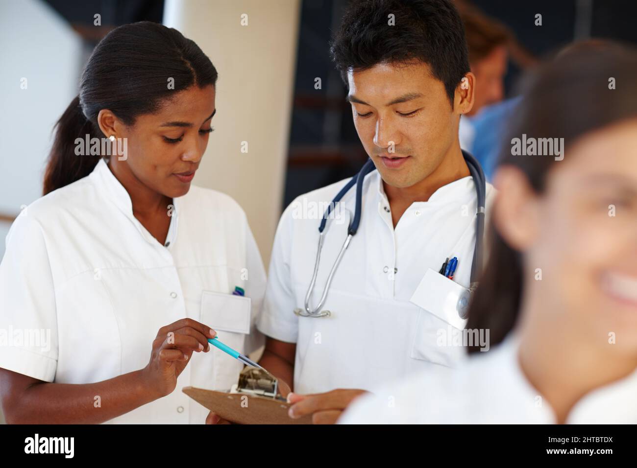 Ich kann Ihnen ein paar Tipps zu dieser Behandlung geben. Aufnahme von zwei medizinischen Fachkräften, die ein Dokument diskutieren. Stockfoto