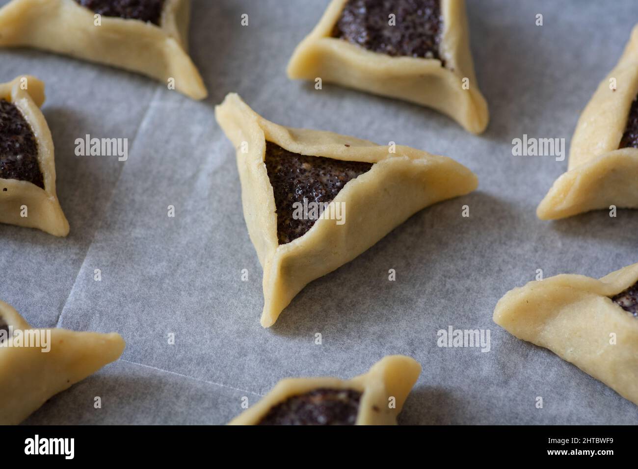 Vorgebackene 'Haman Pockets', auch bekannt als Hamantashen, ein aschkenasisch-jüdisches dreieckiges gefülltes Plätzchen, das normalerweise mit dem jüdischen Feiertag in Verbindung gebracht wird Stockfoto