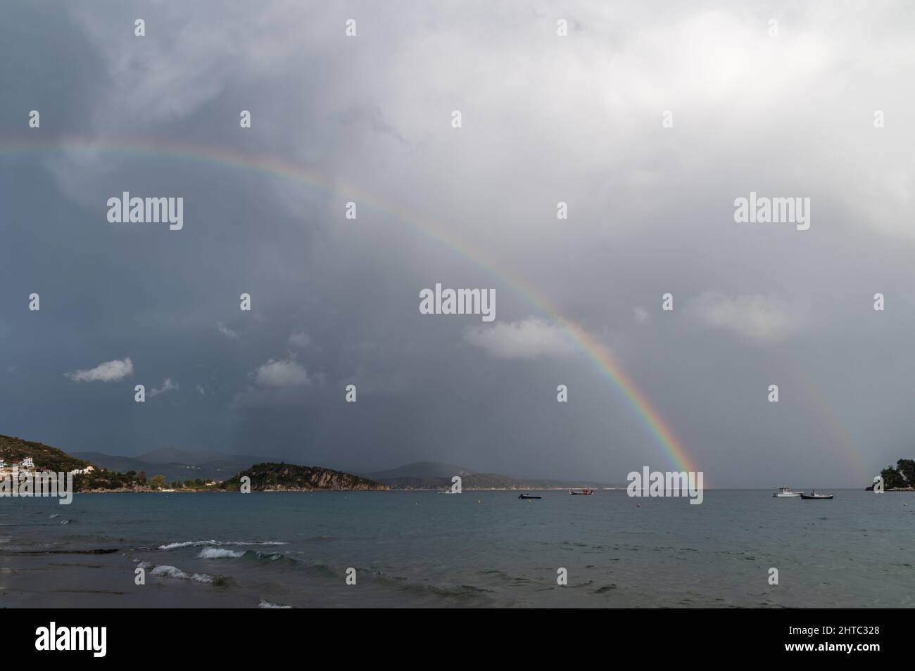 Regenbogen- und Fischerboote auf See. Das Foto wurde an einem bewölkten Tag aufgenommen Stockfoto