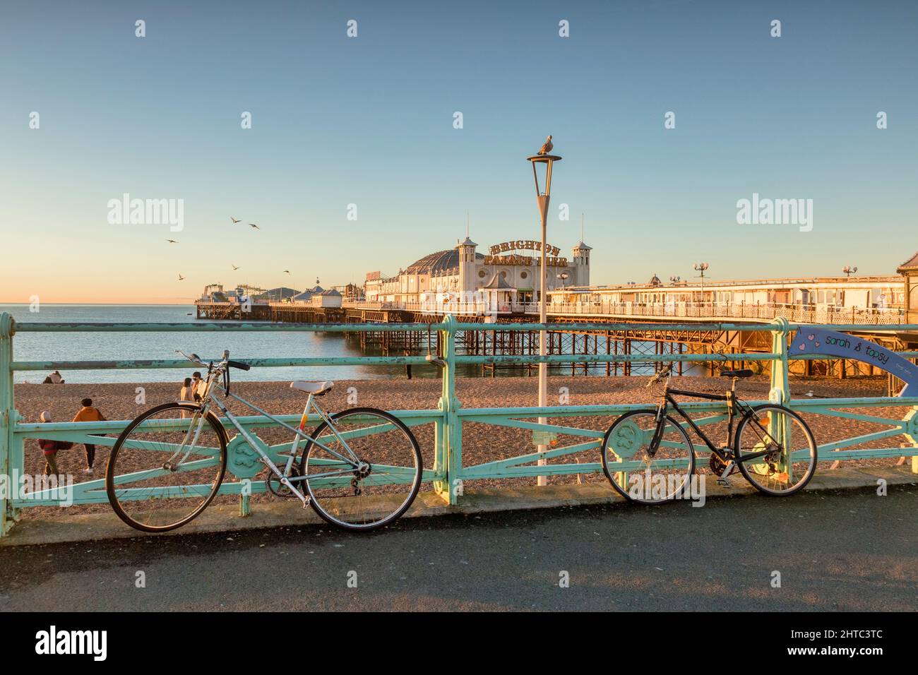 14. Januar 2022: Brighton, East Sussex, UK - Brighton Pier an einem sonnigen Wintermorgen, mit Fahrrädern auf der Promenade. Stockfoto