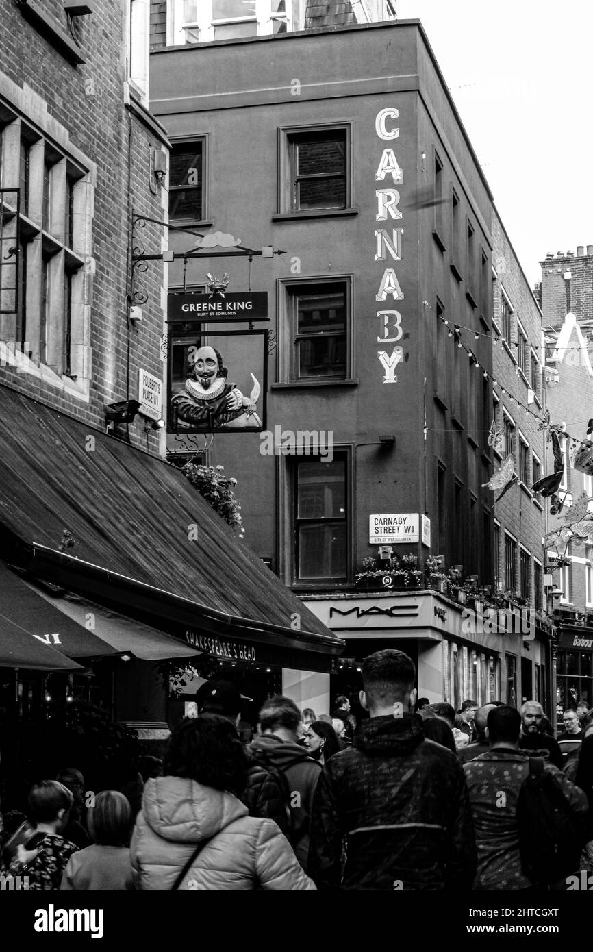 Vertikale Graustufenaufnahme der Carnaby Road in Soho, London, Großbritannien Stockfoto