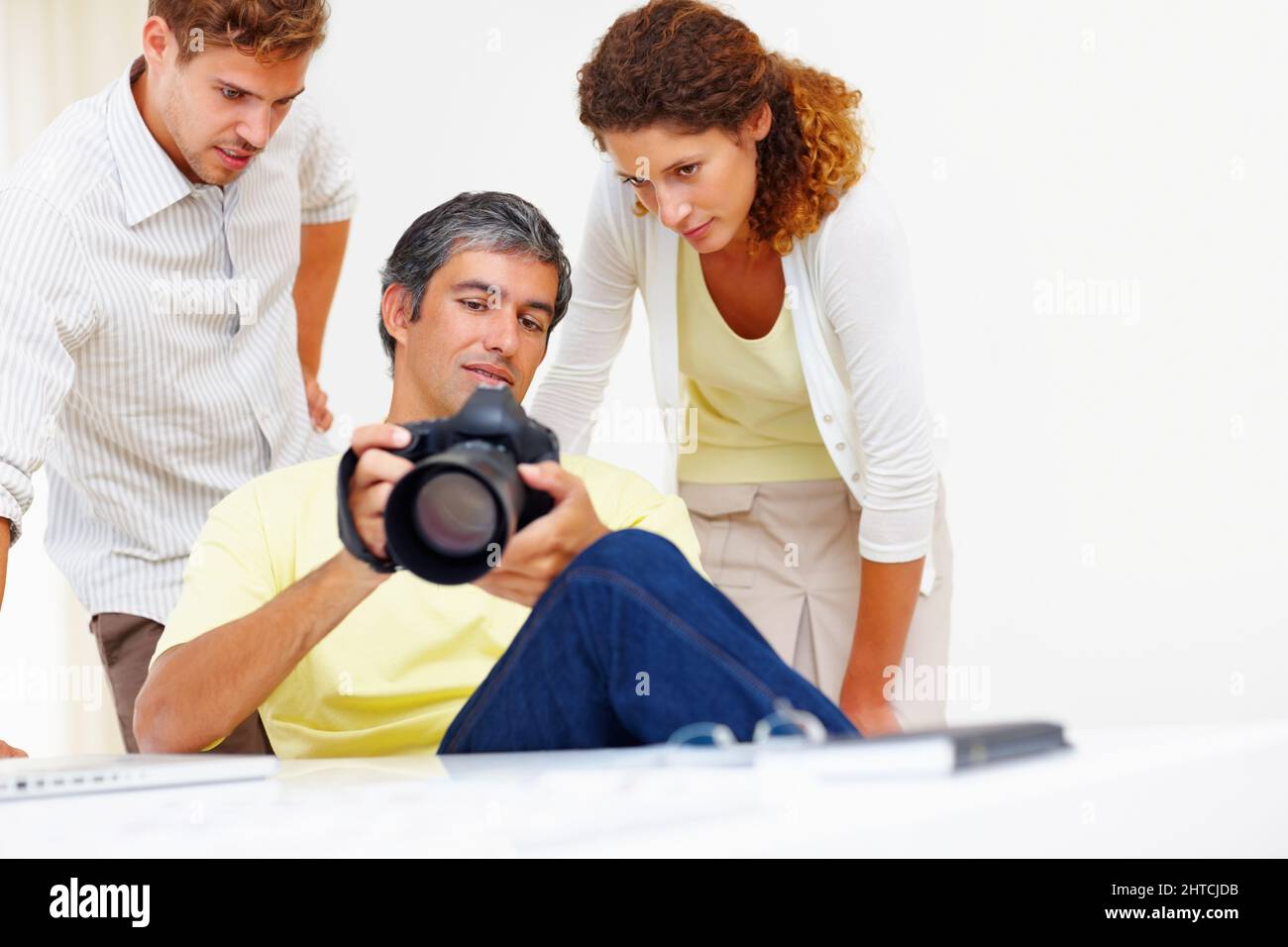Fotografen, die Bilder in der Kamera betrachten. Männlicher Fotograf, der seinen Kollegen in seiner Kamera Bilder zeigt. Stockfoto