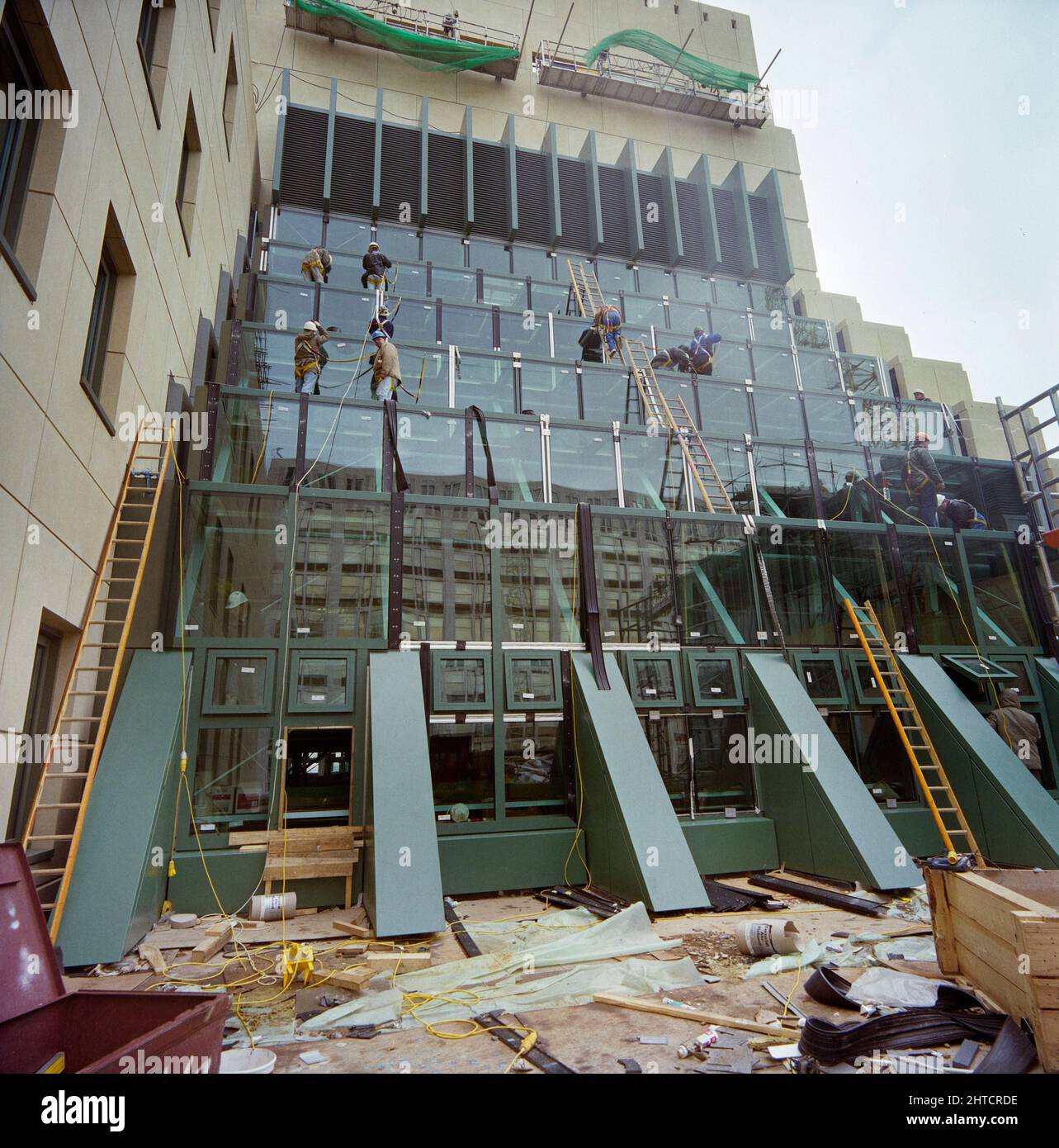 Vauxhall Cross, Albert Embankment, Vauxhall, Lambeth, London, 27/03/1992. Ein Team von Fenstermonteuren arbeitet an der Installation eines stufenförmigen Atriums an der Nordseite des Vauxhall Cross. Vauxhall Cross, auch bekannt als SIS oder MI6 Building, wurde vom Architekten Terry Farrell entworfen und von Laing Management Contracting für Regalian Properties gebaut. Es wurde an die Regierung verkauft und wurde zum Hauptsitz des britischen Geheimdienstes oder MI6. Laing gewann den Auftrag für das Gebäude im Jahr 1989, wobei die Bauarbeiten 1990 begannen und die Fertigstellung der Struktur Platz nahm Stockfoto