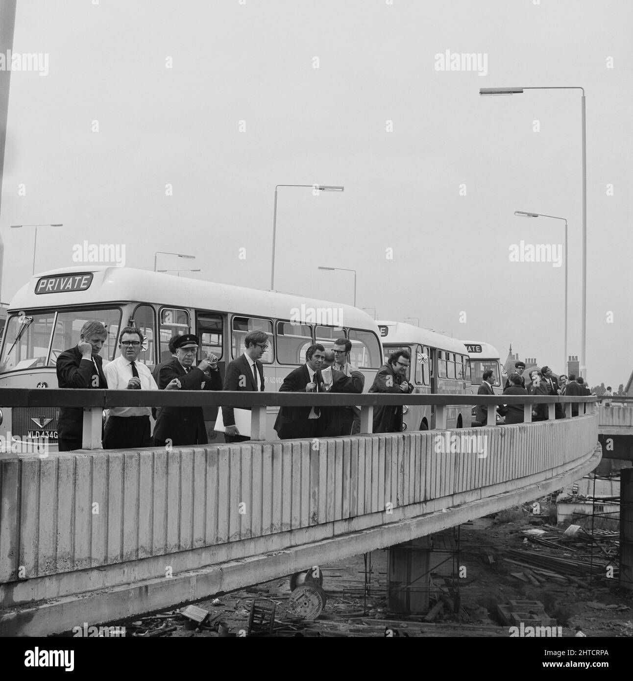 Westway Flyover, A40, Kensington and Chelsea, London, 28/07/1970. Journalisten bei der Eröffnung der Westway Flyover, die die Attika des Kreisels an der Kreuzung mit der West Cross Route säumen, mit ihren Reisebussen hinter ihnen. Die Arbeiten an der Western Avenue Extension begannen am 1.. September 1966 und der Westway, wie er bekannt wurde, wurde am 28.. Juli 1970 offiziell eröffnet. Die erhöhte Autobahn, die die A40 in White City mit der Marylebone Road in Paddington verbindet, liegt bei etwa 2 und#xbd; Meilen waren die längsten in Europa. Der Bau war in sechs Abschnitte gegliedert. Abschnitte 1, 4, 5 &a Stockfoto