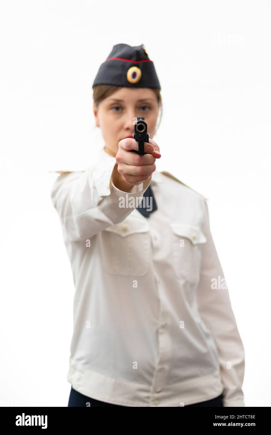 Eine schöne junge Frau russischen Polizist Oberstleutnant in Uniform in einer Mütze mit einer Pistole in den Händen auf einem weißen Hintergrund. Selektiv Stockfoto