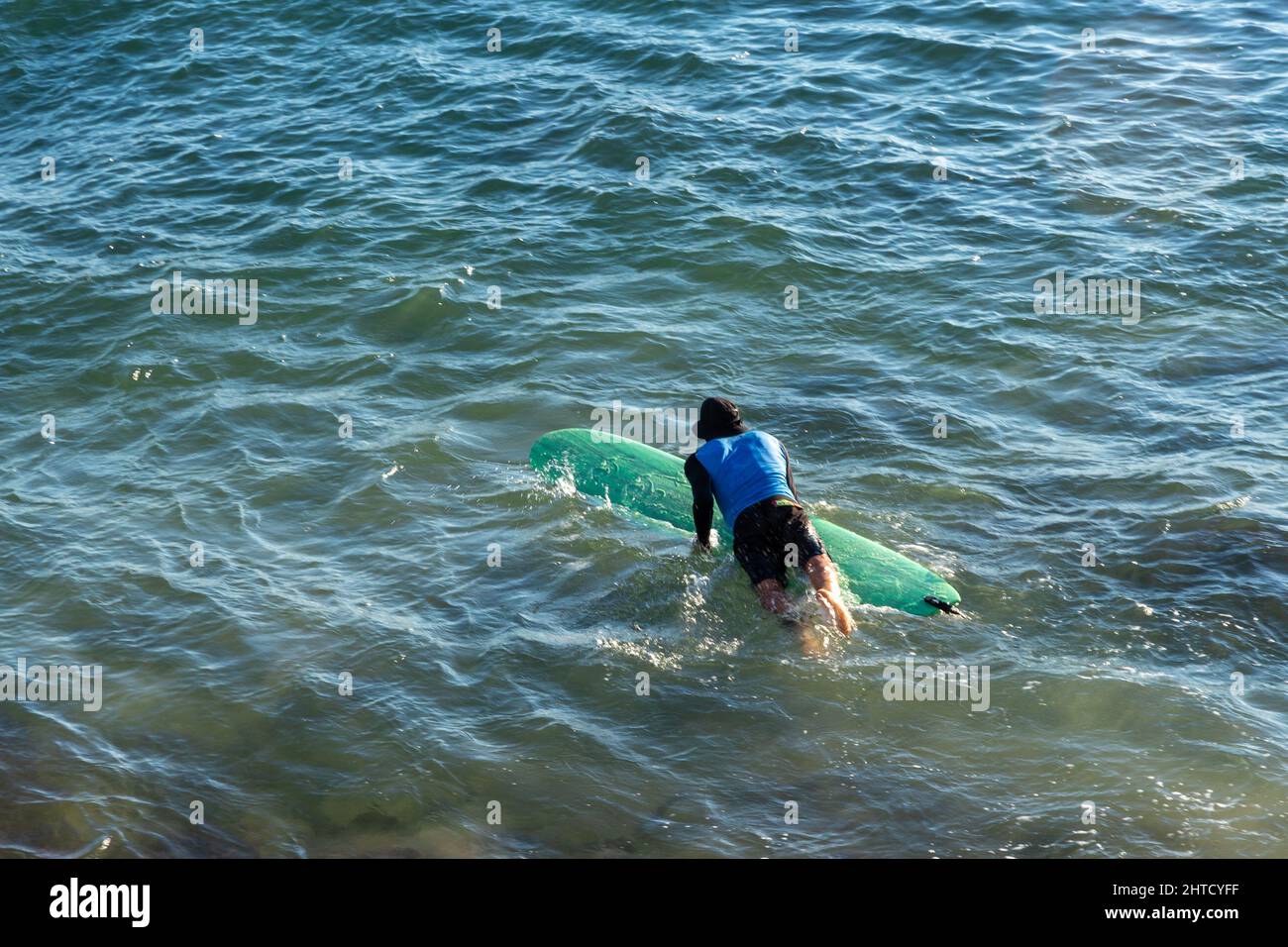 Surfer, der vom Strand Farol da Barra ins Meer kommt. Stockfoto