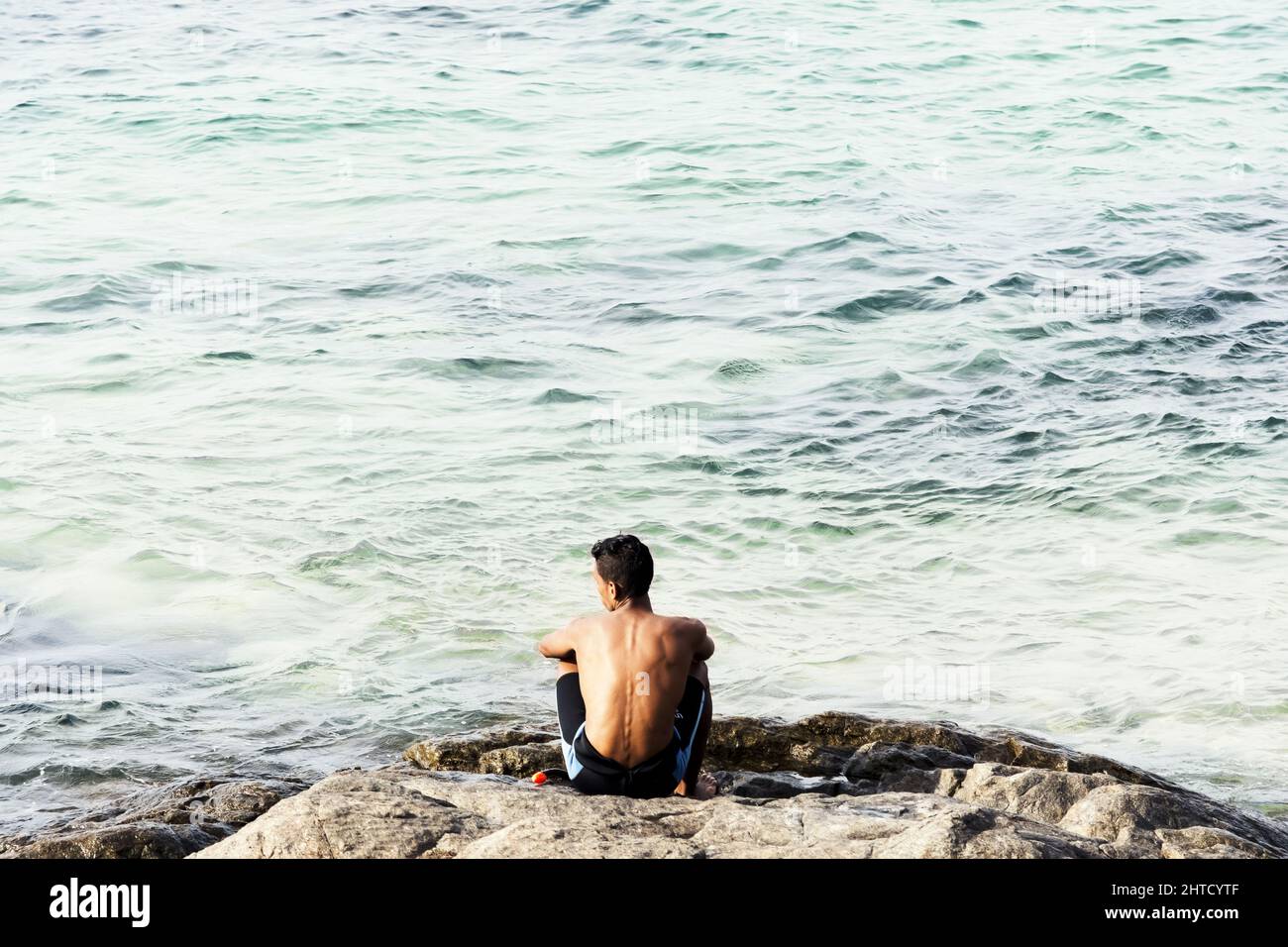 Mann mit Blick auf das Meer am Strand von Porto da Barra in Salvador, Bahia, Brasilien. Stockfoto