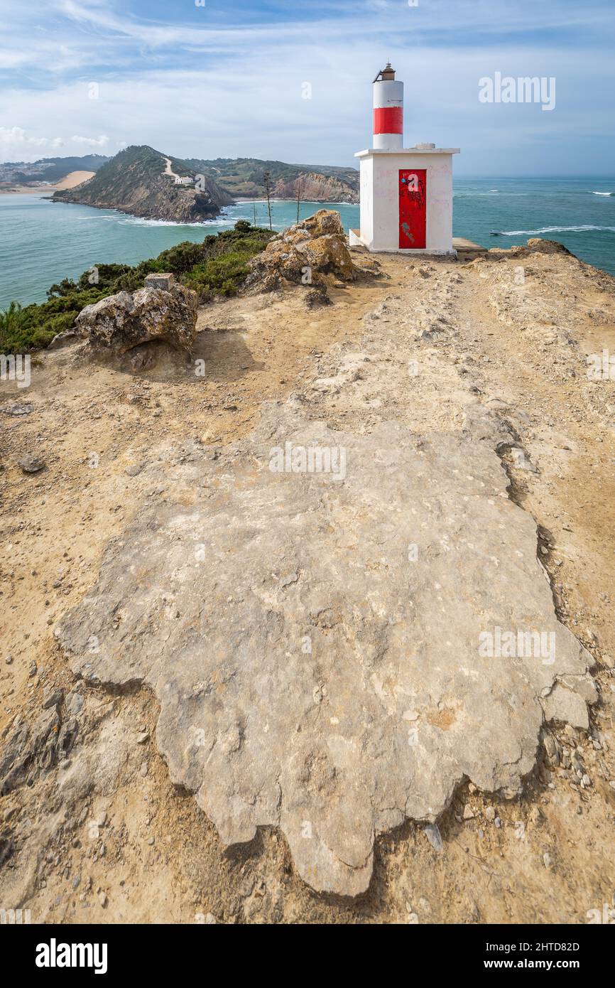 Klippen und Leuchtturm am Strand Sao Martinho do Porto, Portugal Stockfoto