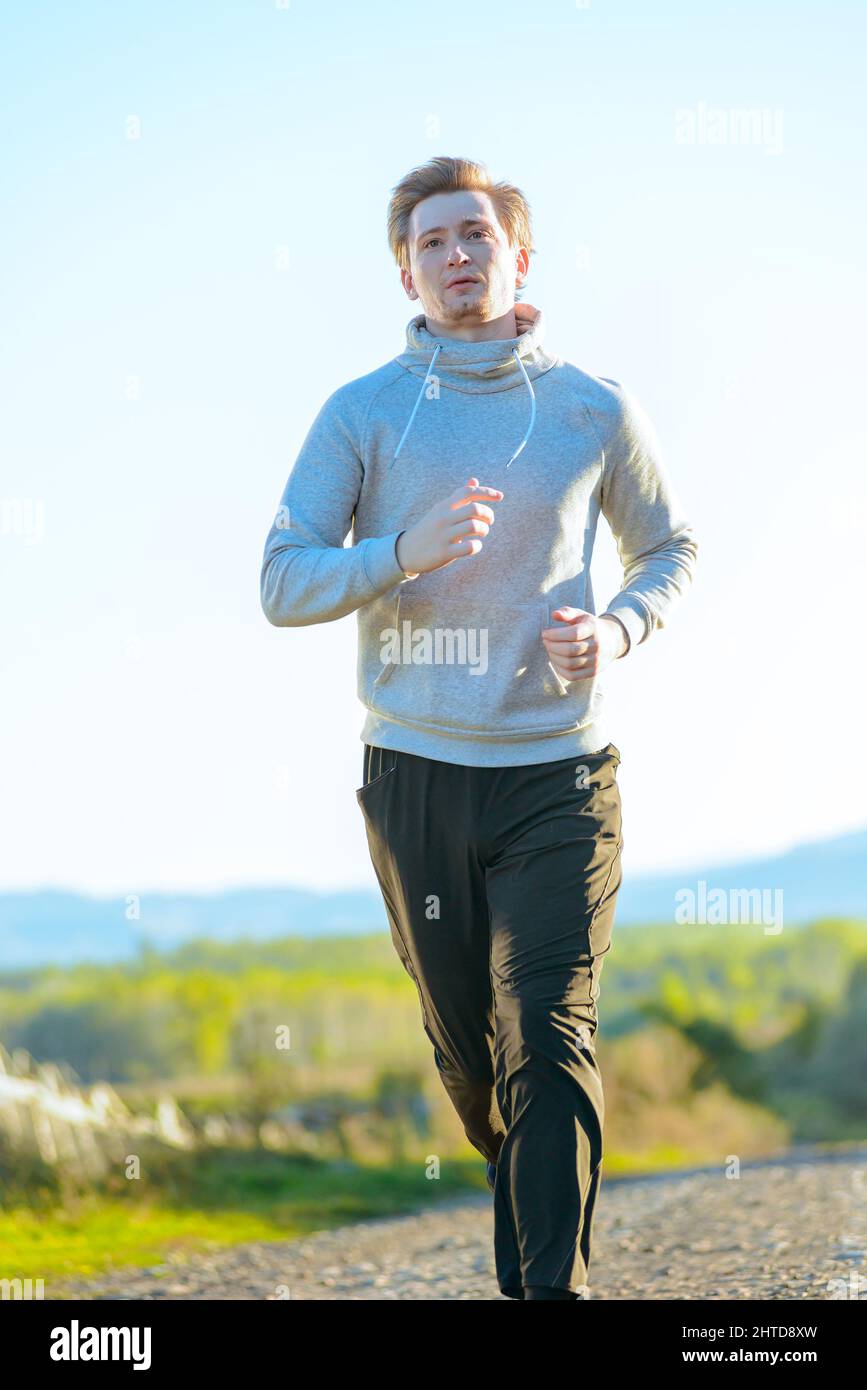 Jogging Mann Joggen in ländlicher Natur an schönen Sommertag. Sport Fitness Modell kaukasischen Ethnizität Training im Freien. Stockfoto