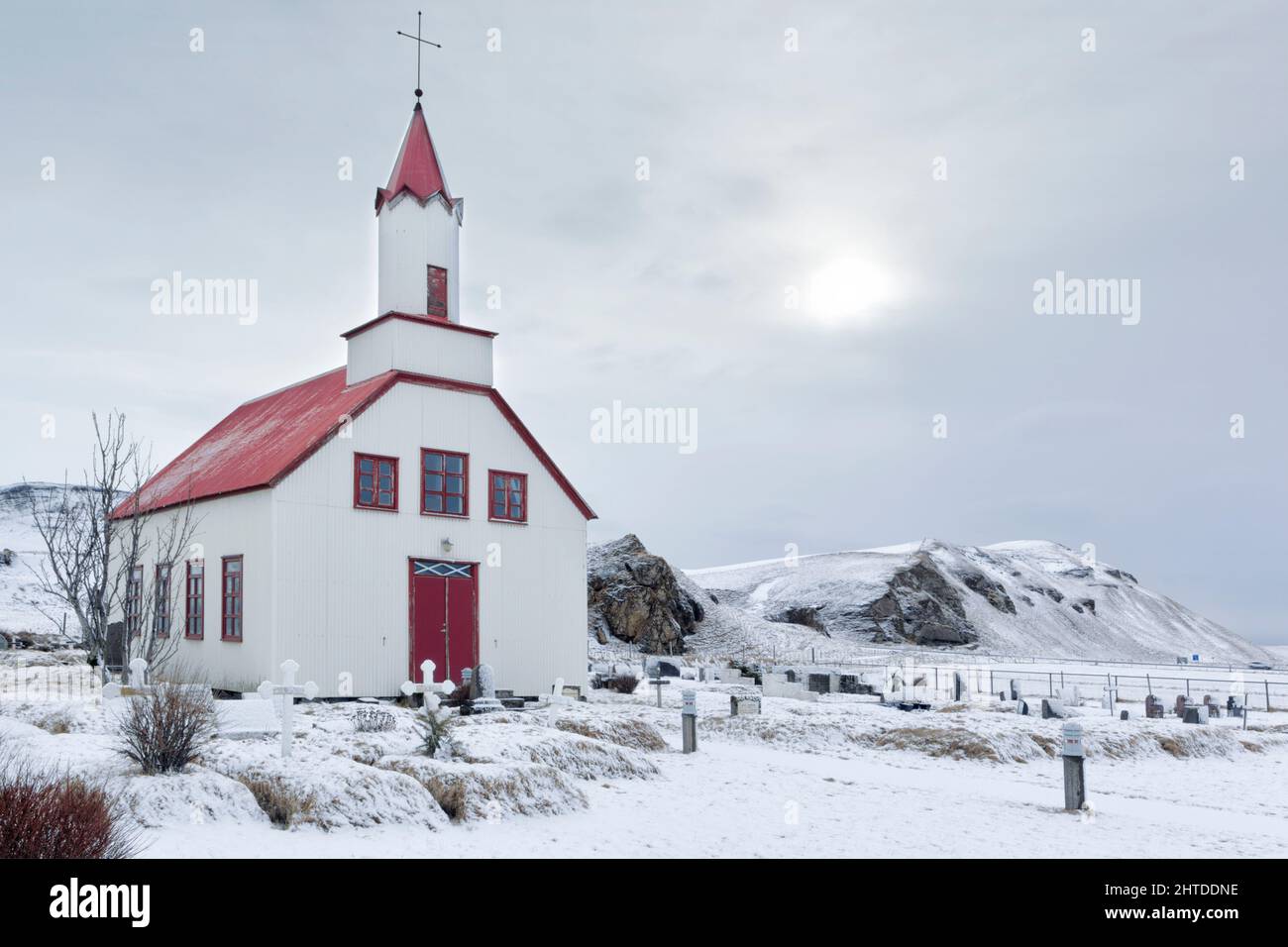 Ländliche isländische Kirche, umgeben von Schnee bei Skeiðflatarkirkja in der Region Mýrdalshreppur am südlichen Rand Islands Stockfoto