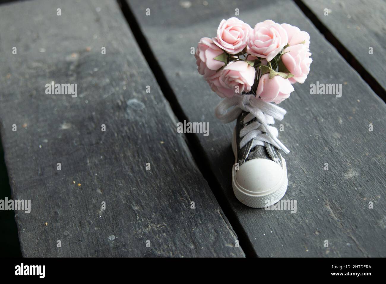 Blumen, Hintergrund. Ein wunderschöner Blumenstrauß und ein Sneaker. Stockfoto