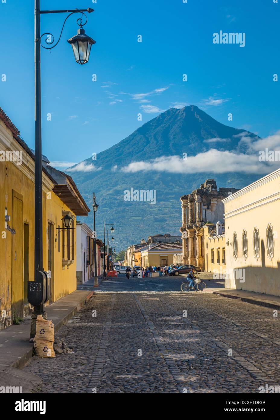 Eine Antigua Guatemala-Straße mit ihren Gebäuden im Kolonialstil und dem Vulkan Agua in der Ferne, Guatemala Stockfoto