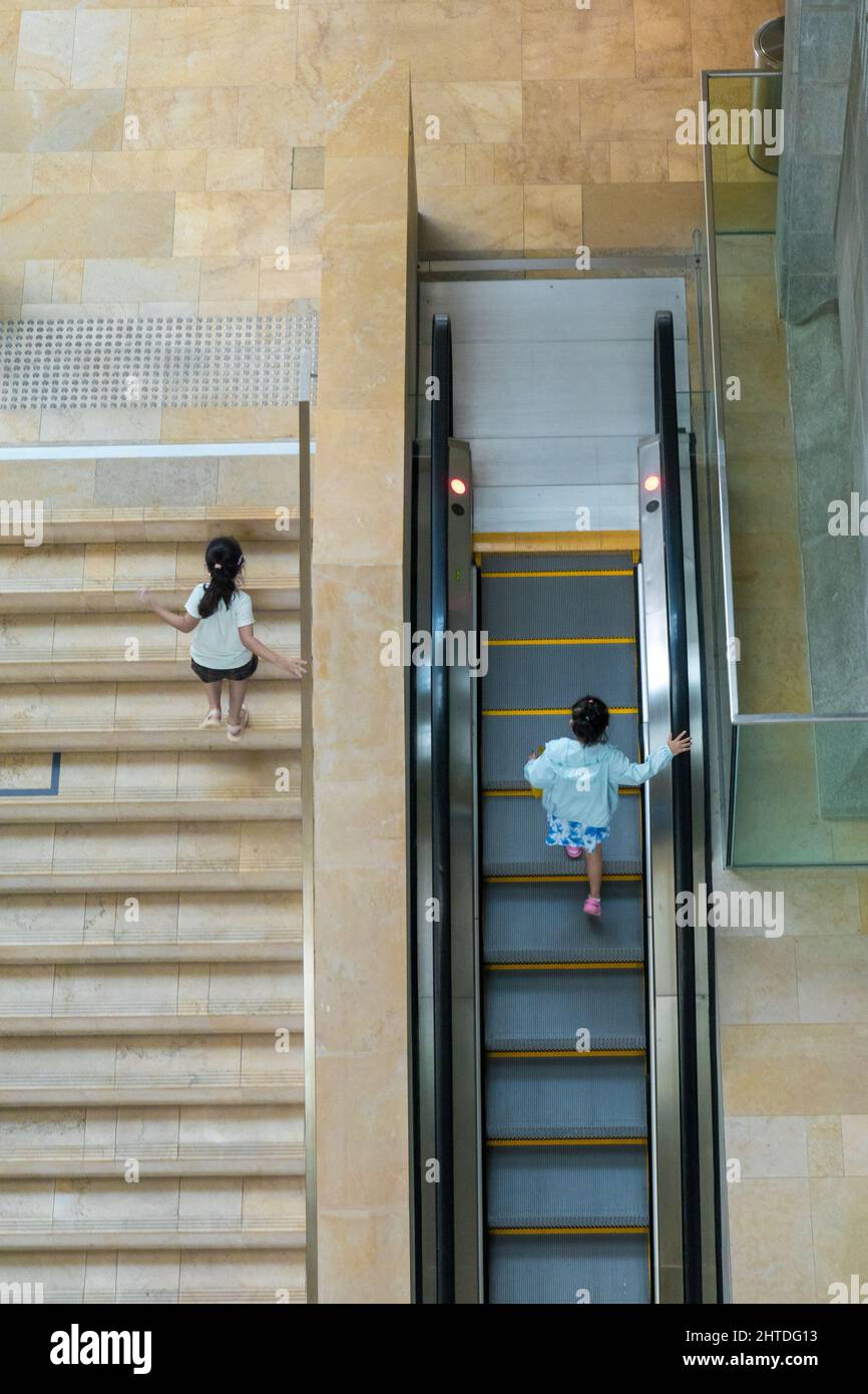 Kinder, die in Singapur die Treppe hoch gegeneinander antreten Stockfoto