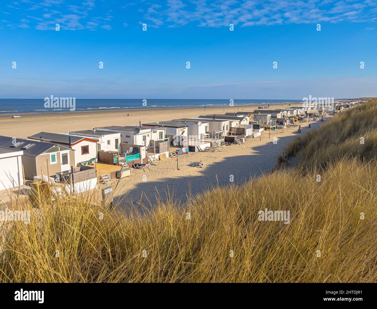 Strandhütten oder Häuser unter blauem Himmel. Strandbadehütten mit weißem Sand und klarem blauen Himmel. Strandszene von oben gesehen. Stockfoto