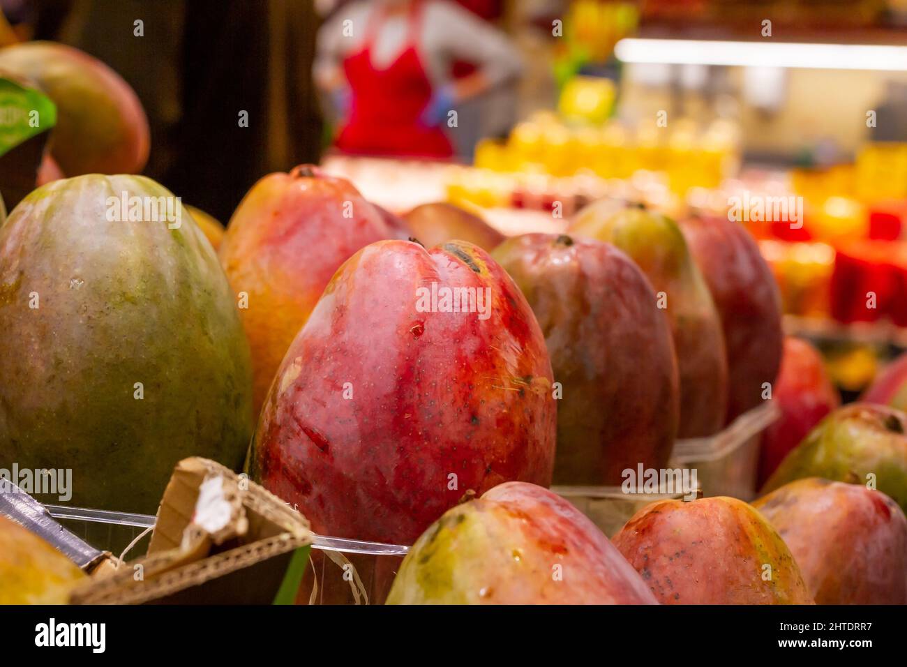 Eine Nahaufnahme von roten Mangos, die in einer Reihe auf einem brasilianischen Markt organisiert werden Stockfoto