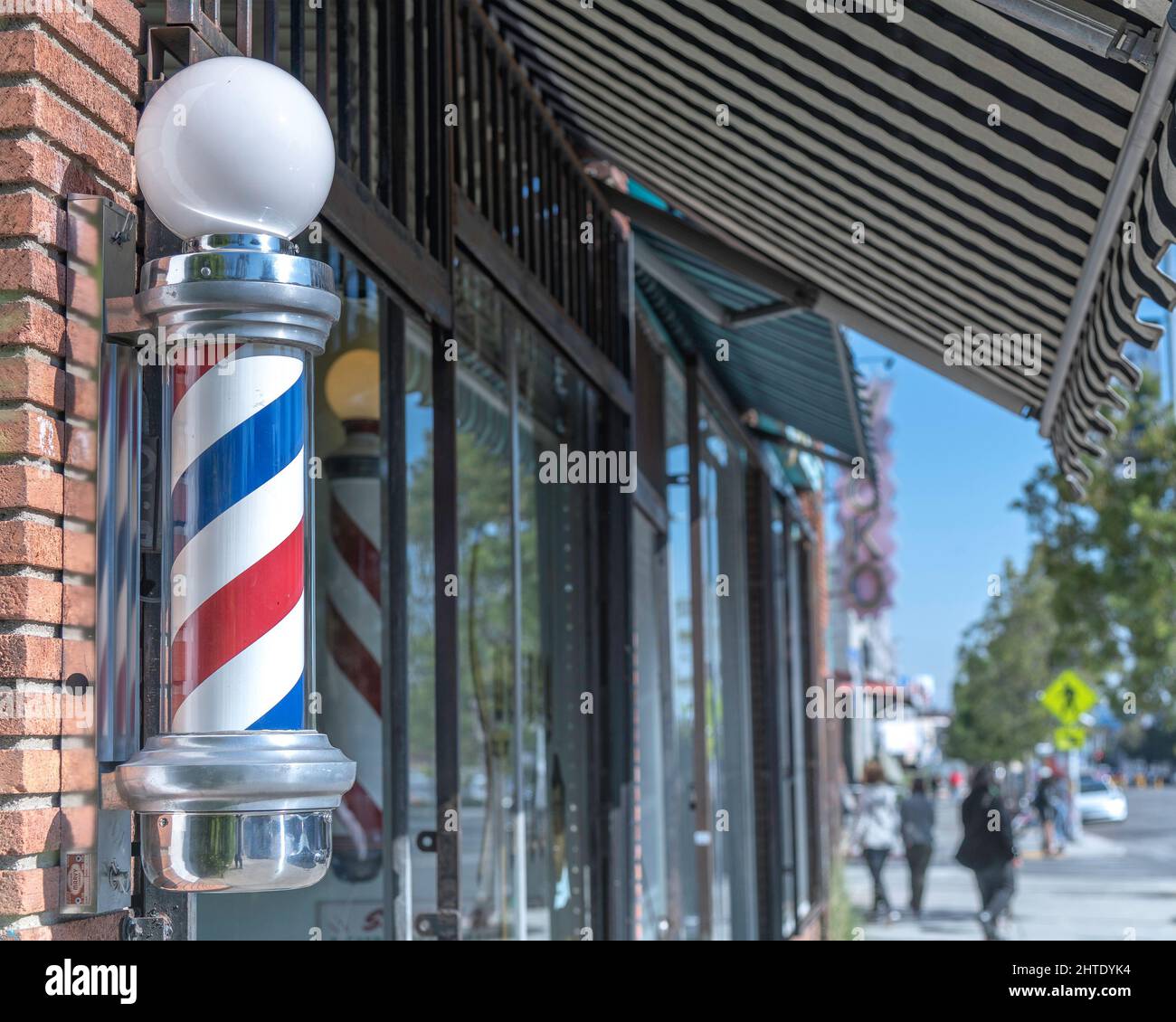 Los Angeles, CA, USA - 25. Februar 2022: Nahaufnahme eines traditionellen Barberpols vor einem Friseur in Los Angeles, CA. Stockfoto