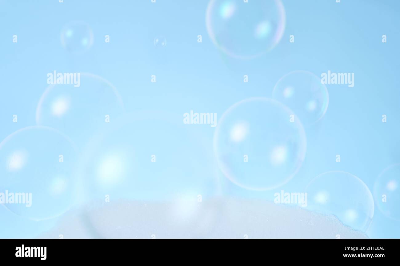 Verschwommenes Foto von Seifenblasen auf blauem Hintergrund. Stockfoto