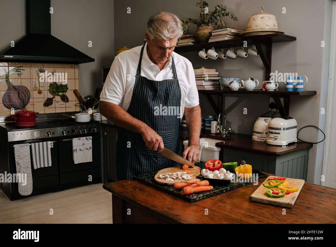 Kaukasische männliche Küche in der Küche hackt Gemüse Stockfoto