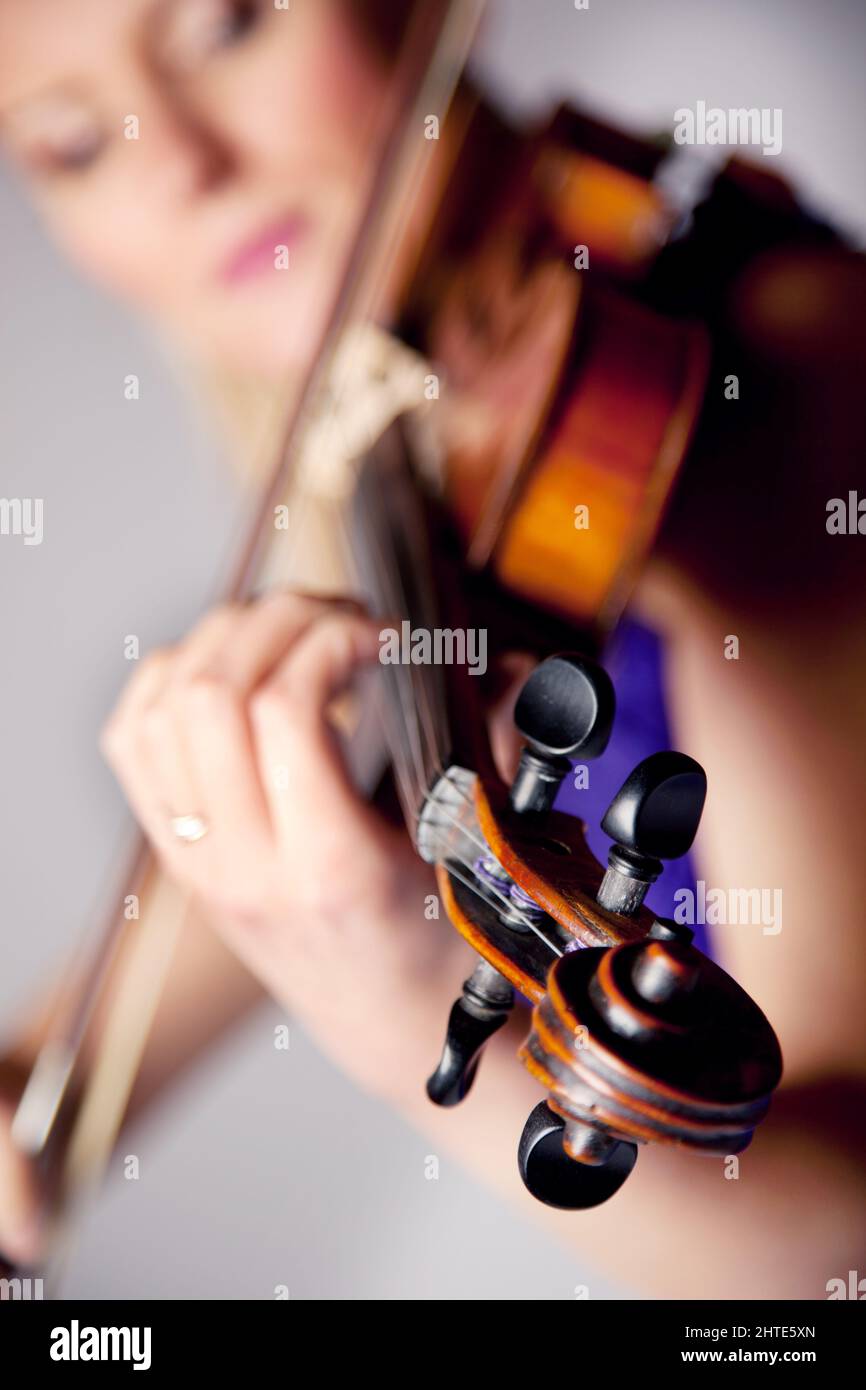 Fasziniert von der Schönheit der Musik. Studioaufnahme einer schönen jungen Frau, die Geige spielt. Stockfoto