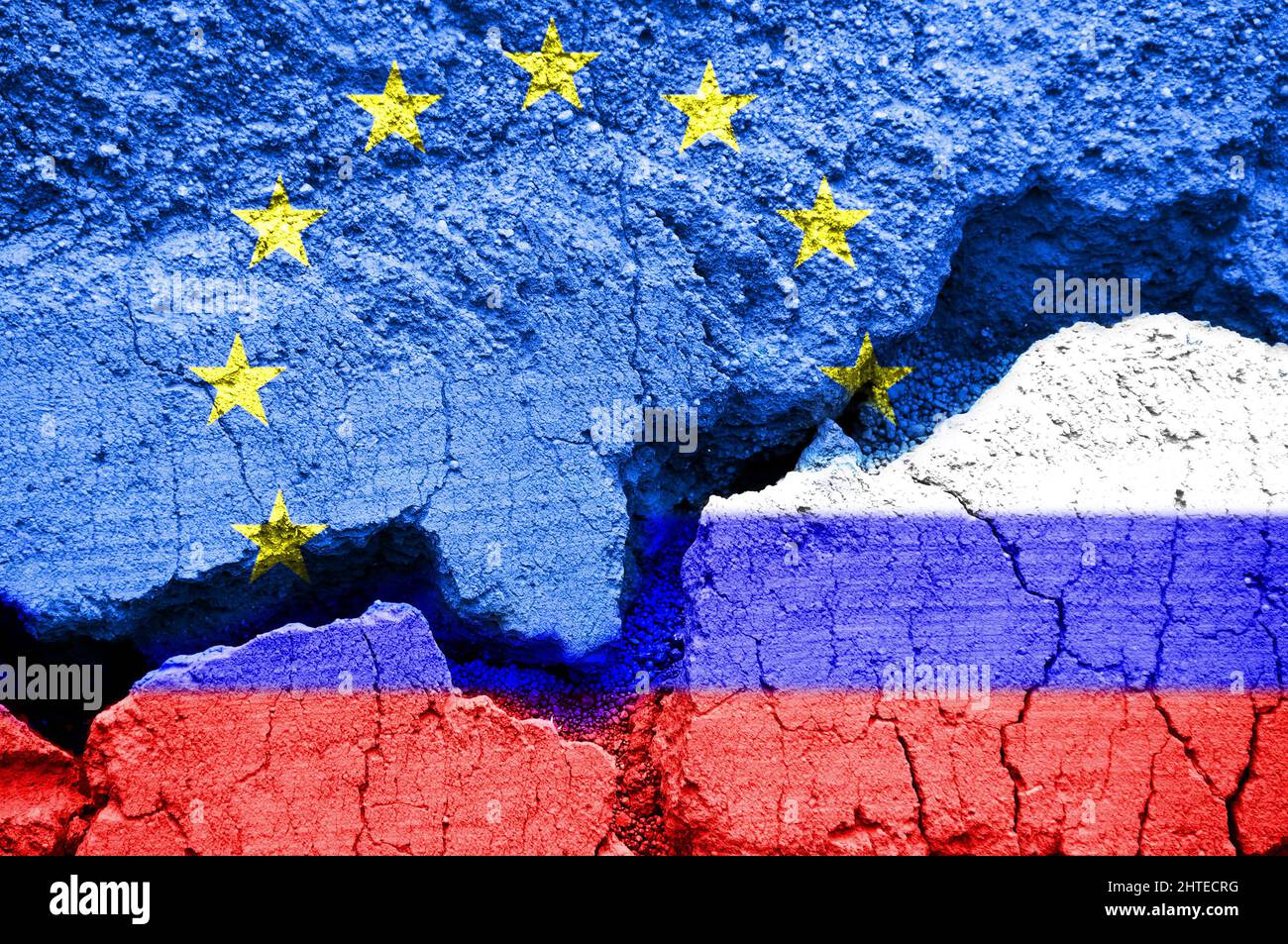 Russische und europäische Flaggen auf gebrochenem Boden. Europa und Russland Krisenkonzept während des Ukraine-Krieges Stockfoto