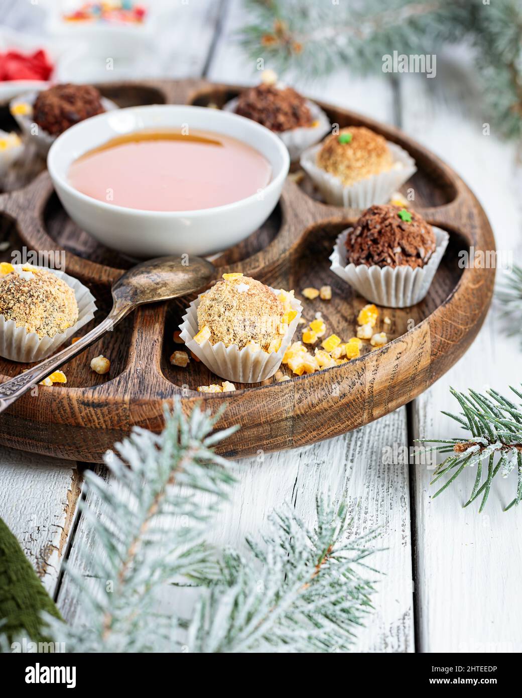 Nahaufnahme von Schokoladenbonbons mit Honig. Natürliche handgemachte Schokolade aus Bio-Zutaten. Weißer Holzhintergrund. Vertikale Aufnahme. Speicherplatz kopieren. Top Vie Stockfoto