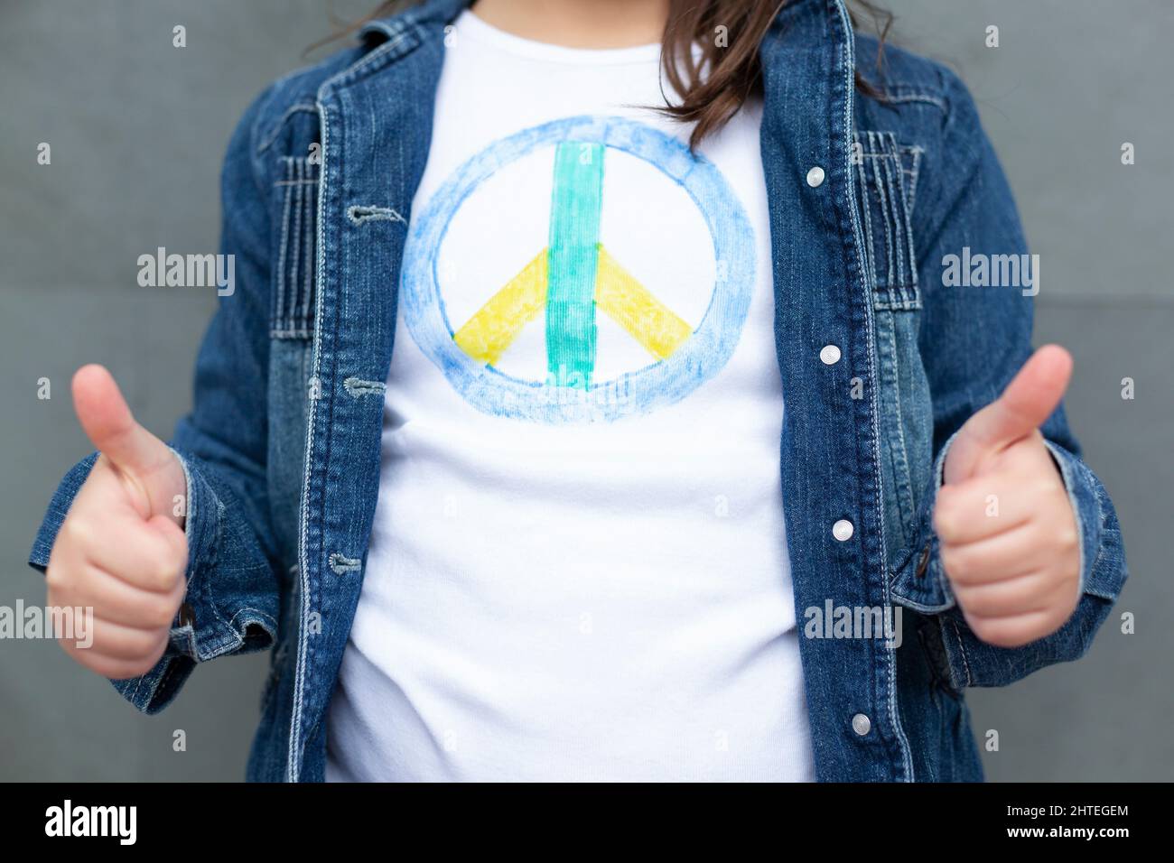 Nahaufnahme einer nicht erkennbaren Person, die das Peace Symbol T-Shirt trägt, mit Daumen nach oben. Stockfoto