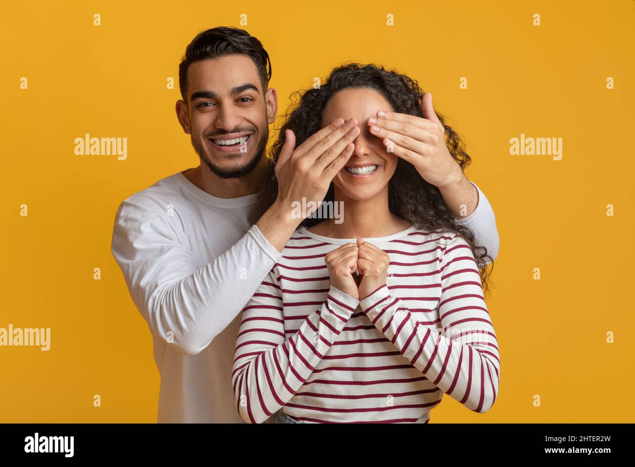 Fröhlicher Arabischer Kerl Spielt Guess Who Mit Seiner Freundin Und Bedeckt Ihre Augen Stockfoto