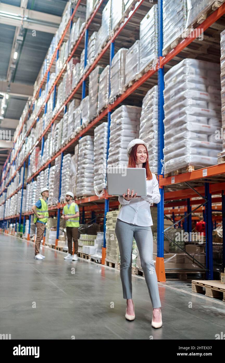 Frau, die im Lager auf einem Laptop arbeitet Stockfoto