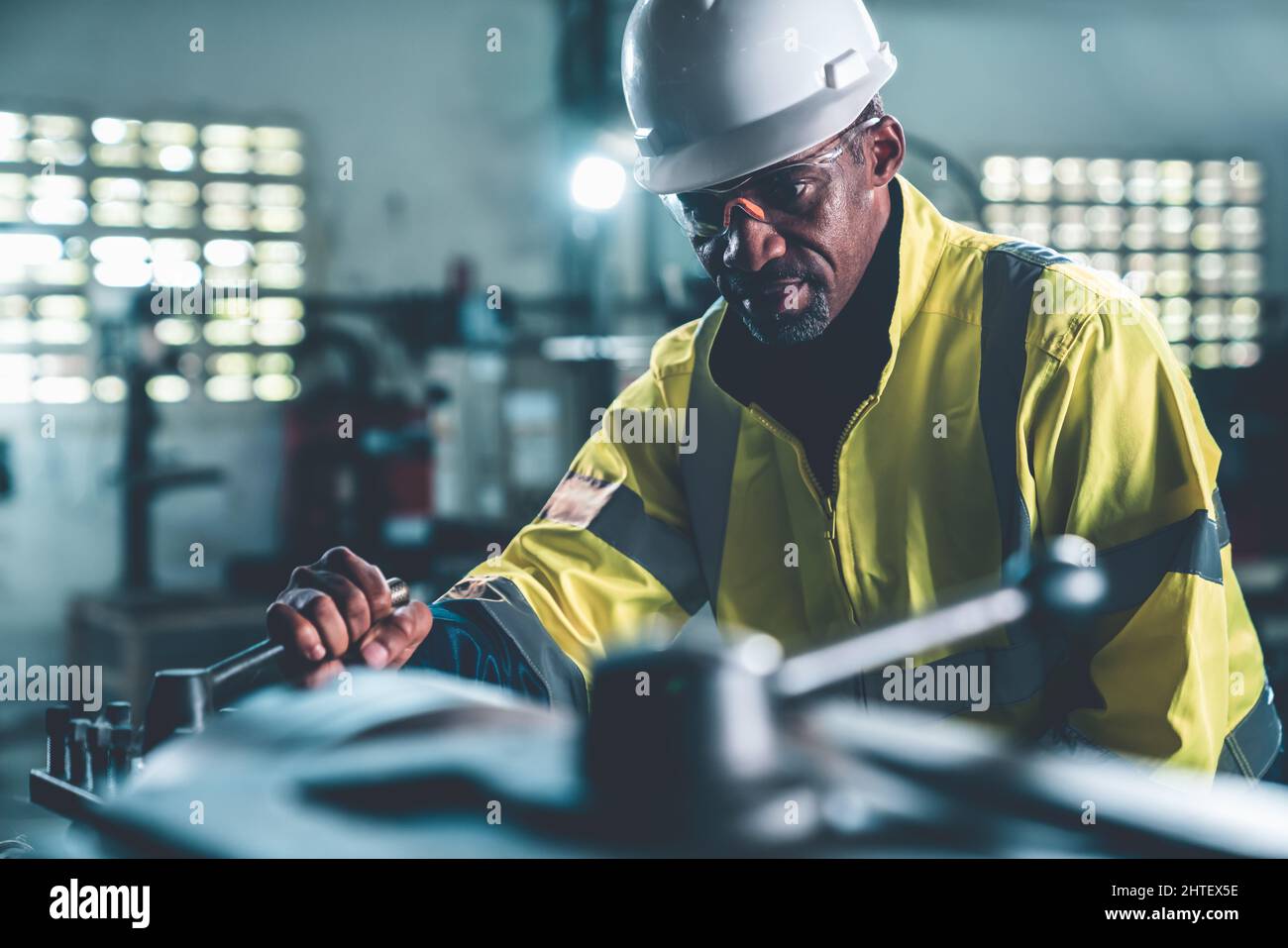 Fabrikarbeiter oder Ingenieur machen Maschinenarbeit in versierter Fertigungswerkstatt. Industrielle Menschen und Fertigung Arbeitskonzept . Stockfoto